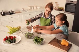 Mother,And,Daughter,Cooking,Salad,Together,In,Kitchen