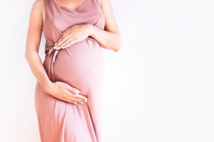 Pregnant,Woman,In,Dress,Holds,Hands,On,Belly,On,A
